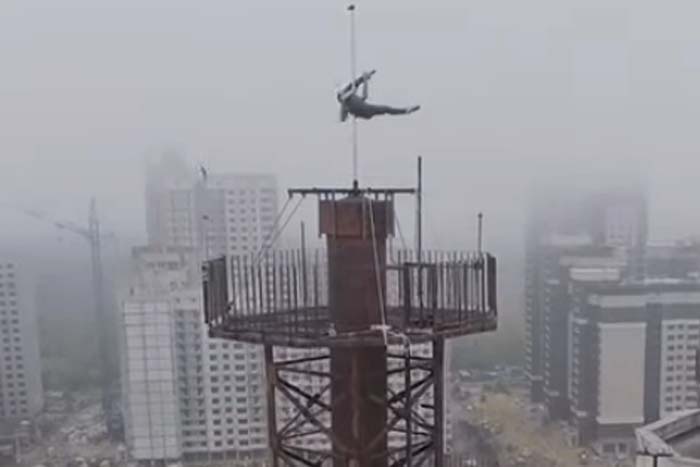 Mulher acrobata faz pole-dance em lugares inusitados 